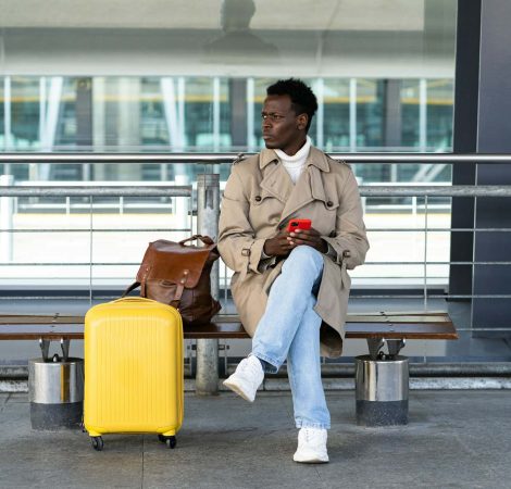 black-traveler-man-with-suitcase-sitting-on-bench-in-airport-terminal-calling-and-looking-for-taxi.jpg black-traveler-man-with-suitcase-sitting-on-bench-in-airport-terminal-calling-and-looking-for-taxi.jpg